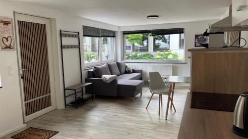 a living room with a couch and a table at OASE im grünen Hinterhof, EG, Ruhe, Terrasse, Carport, free PayTV, Kaffee&Tee, Fahrräder in Duisburg