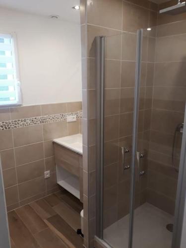 une salle de bain avec douche et lavabo dans l'établissement Charmante maison, proche de DEAUVILLE, à Saint-Étienne-la-Thillaye