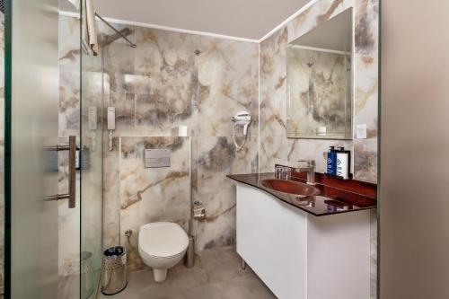 a bathroom with a toilet and a sink and a shower at Dedeman Kemer Resort - Ultra All Inclusive in Kemer
