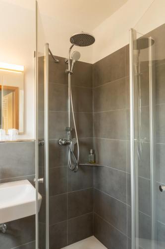 a shower with a glass door in a bathroom at Hotel Restaurant Ancho in Cölbe