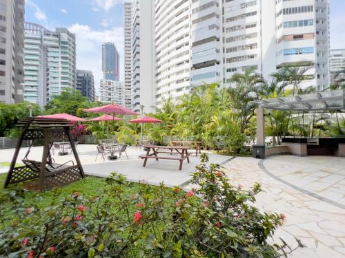 a patio with tables and umbrellas in a city at Coliwoo Orchard - CoLiving in Singapore