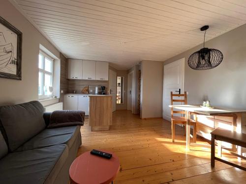 a living room with a couch and a table and a kitchen at Fischerhus37 FeW Jasmund in Polchow