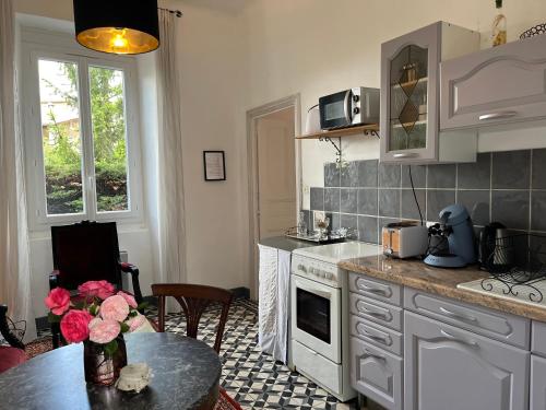 une cuisine avec une table et une cuisinière four supérieur dans l'établissement Gite pour 2 personnes dans agréable maison d'hôtes, à Saint-Florent-sur-Auzonnet