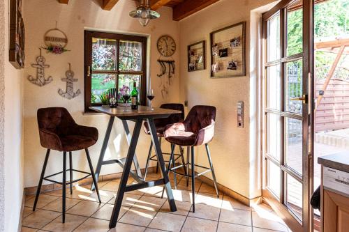 a kitchen with a table and two bar stools at Wellnessparadies mit Sauna und Whirlpool in Krakow am See