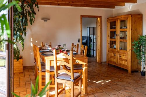 a dining room with a wooden table and chairs at Wellnessparadies mit Sauna und Whirlpool in Krakow am See