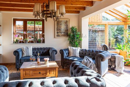 a living room with couches and a table at Wellnessparadies mit Sauna und Whirlpool in Krakow am See