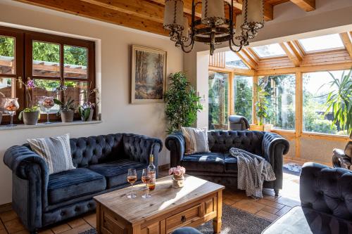 a living room with couches and a table at Wellnessparadies mit Sauna und Whirlpool in Krakow am See