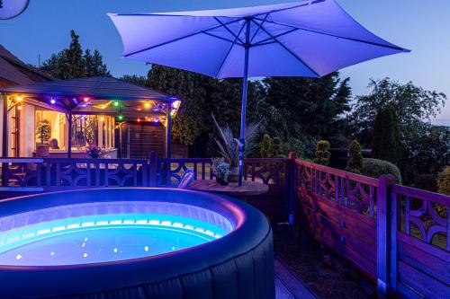 a hot tub with an umbrella on a deck at Wellnessparadies mit Sauna und Whirlpool in Krakow am See