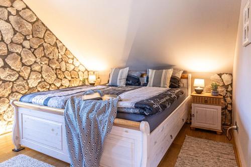 a bed in a room with a stone wall at Wellnessparadies mit Sauna und Whirlpool in Krakow am See