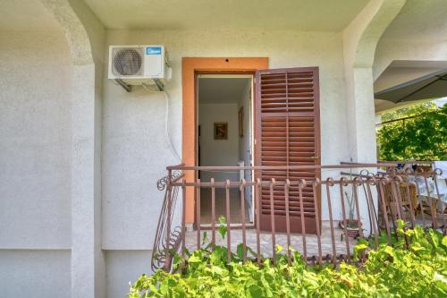 a house with a balcony with a door at Baka Zlata Apartments in Petrovac na Moru