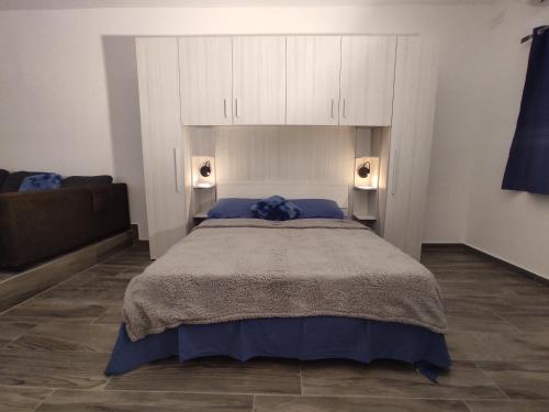 a bedroom with a large bed with white cabinets at Charming Townhouse - Steps from Waterfront in Marsaxlokk