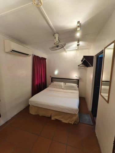a bedroom with a white bed and a red curtain at Red Inn Court in George Town