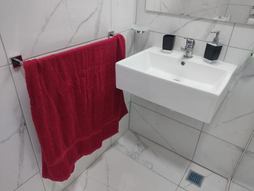 a bathroom with a red towel hanging next to a sink at Charming Townhouse - Steps from Waterfront in Marsaxlokk