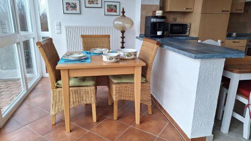 a kitchen with a wooden table with chairs and a counter at Odenwald Ferienwohnung - Infrarot-Sauna-Parkplatz-Waschmaschine-WLAN in Schwanheim