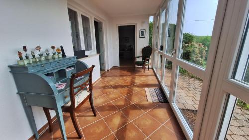 a room with a table and chairs and a balcony at Odenwald Ferienwohnung - Infrarot-Sauna-Parkplatz-Waschmaschine-WLAN in Schwanheim