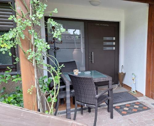 a patio with a table and chairs on a porch at Odenwald Ferienwohnung - Infrarot-Sauna-Parkplatz-Waschmaschine-WLAN in Schwanheim