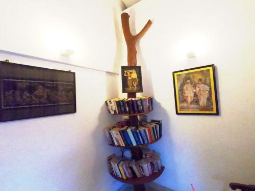 a book shelf filled with books next to a wall at Villa Thalpe Breeze in Unawatuna
