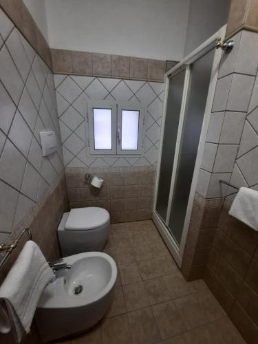 a bathroom with a toilet and a sink and a shower at Viccinella House in Capranica