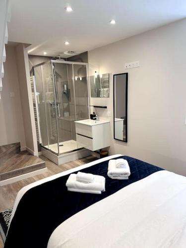 - une chambre avec une douche et un lit avec 2 serviettes dans l'établissement Le Bleu du Mont, à Avranches