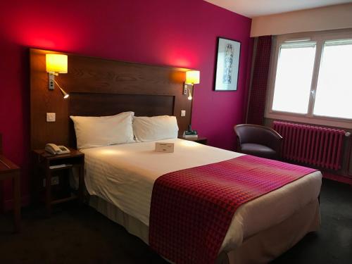 a hotel room with a bed and a red wall at Logis Hotel & Restaurant La Paix in Le Nouvion-en-Thiérache