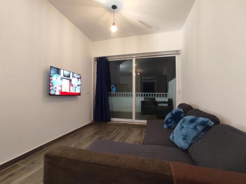 a living room with a couch and a flat screen tv at Charming Townhouse - Steps from Waterfront in Marsaxlokk
