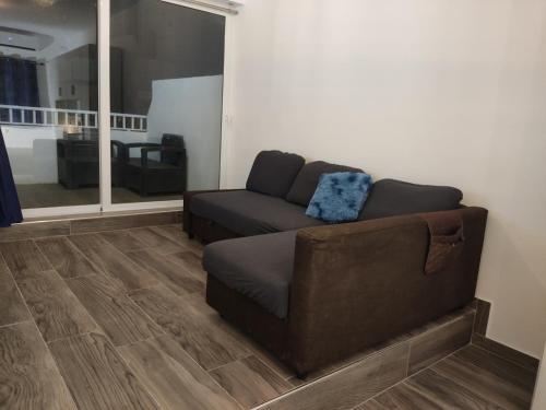a living room with a couch and a large window at Charming Townhouse - Steps from Waterfront in Marsaxlokk