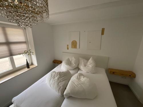 a bedroom with a white bed with white pillows at Fischerhus37 FeWo Kranichwiese in Polchow