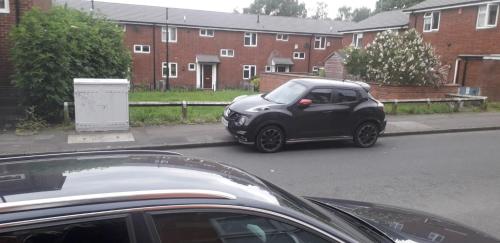 a small car parked on the side of a street at Sports City Guest House in Manchester