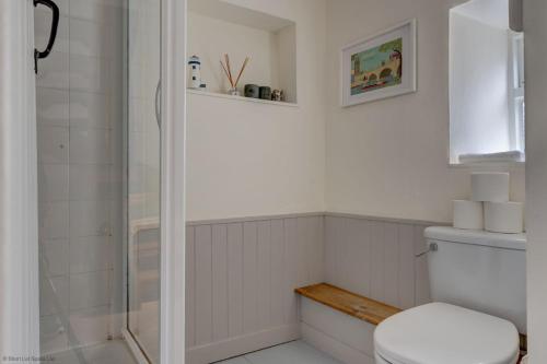 a white bathroom with a shower and a toilet at The White Cottage in Woodstock