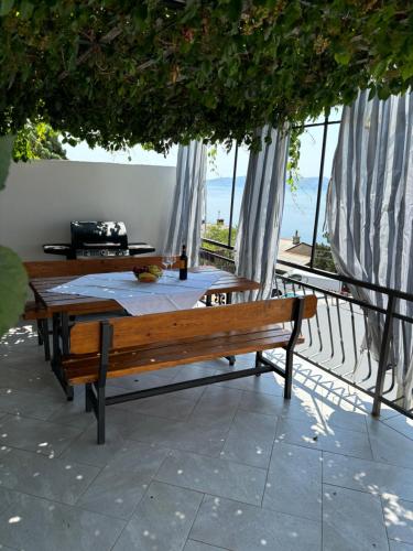 een houten bank op een patio met een tafel bij Apartment Sanja in Senj