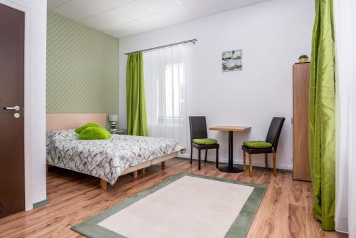 ein Schlafzimmer mit einem Bett, einem Tisch und Stühlen in der Unterkunft Green Residence in Tallinn