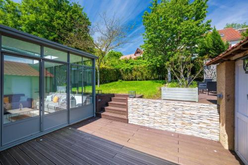 une maison en verre avec une terrasse et un patio dans l'établissement Le Havre d'Argenteuil / Maison pour 10 personnes, à Argenteuil