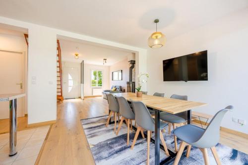 une salle à manger avec une table et des chaises en bois dans l'établissement Le Havre d'Argenteuil / Maison pour 10 personnes, à Argenteuil