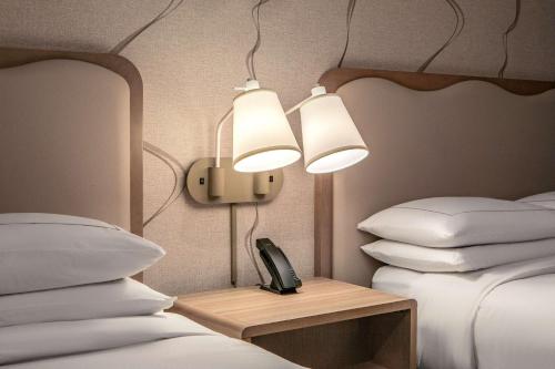 a room with two beds and a phone on a table at DoubleTree by Hilton Hotel and Conference Center Chicago North Shore in Skokie