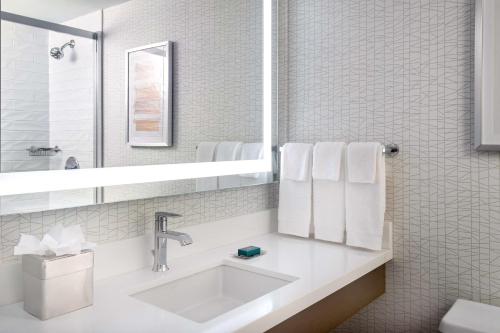 a white bathroom with a sink and a mirror at DoubleTree by Hilton Hotel and Conference Center Chicago North Shore in Skokie
