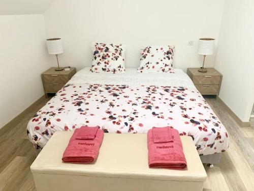 a bedroom with a bed with red towels on it at La BULLE du 235 in Cramant