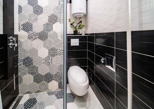 baño con aseo y puerta de ducha de cristal en Rab centar, en Rab