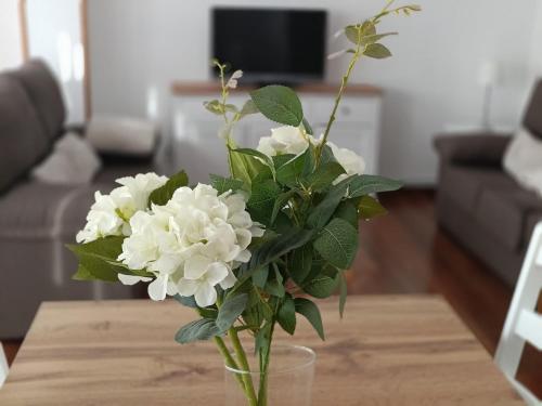 a vase filled with white flowers on a table at Crisol Plaza in Ampuero