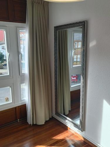a mirror in the corner of a room with curtains at Crisol Plaza in Ampuero