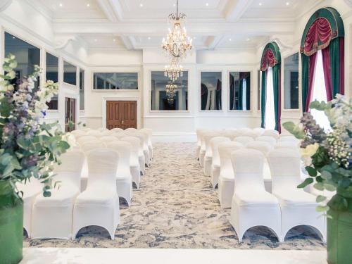 a row of white chairs in a room with windows at The Grand Bristol By Sunday in Bristol