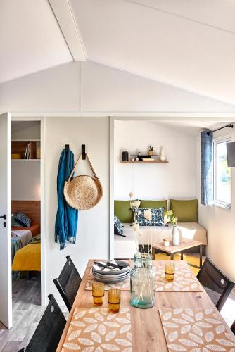 une salle à manger et un salon avec une table et des chaises dans l'établissement Camping Antioche D'Oléron, à La Brée-les-Bains