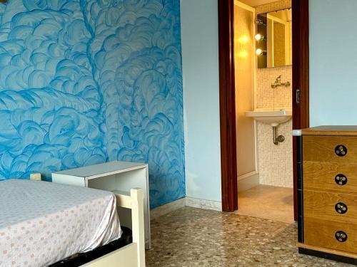 a bedroom with a blue wall with a bed and a sink at Sea View Apartment in Gallipoli