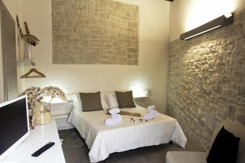 a hotel room with a bed, table and television at Residence San Martino- Rooms & Suite Apartments in Erice