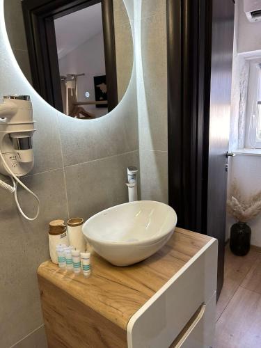 a bathroom with a bowl sink and a mirror at Guest House Exalto in Trogir