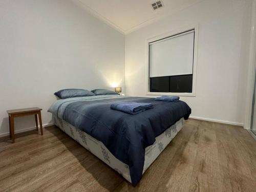 a bedroom with a large bed and a large window at Stockmans in Truganina