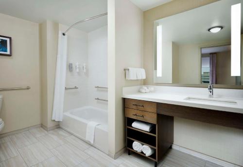 a bathroom with a tub and a sink and a shower at Homewood Suites By Hilton Louisville Downtown in Louisville