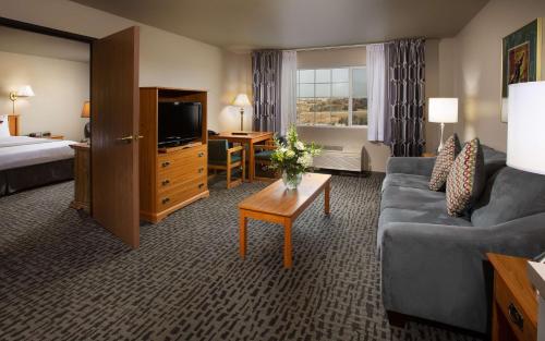 a hotel room with a couch and a bed and a television at Coast Hilltop Inn in Pullman
