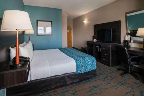 a hotel room with a bed and a desk and a television at Gateway Hotel & Suites, an Ascend Collection Hotel in Ocean City