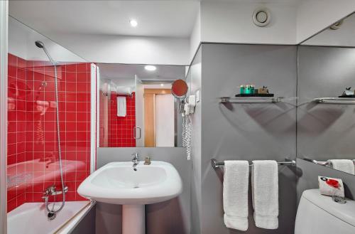 アルブフェイラにあるRocamar Exclusive Hotel & Spa - Adults Onlyの赤いタイル張りの壁、洗面台付きのバスルーム