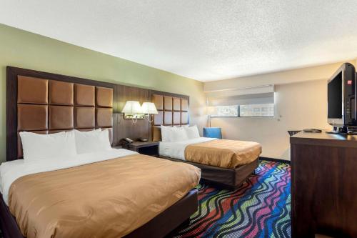 a hotel room with two beds and a flat screen tv at Quality Inn Cookeville in Cookeville